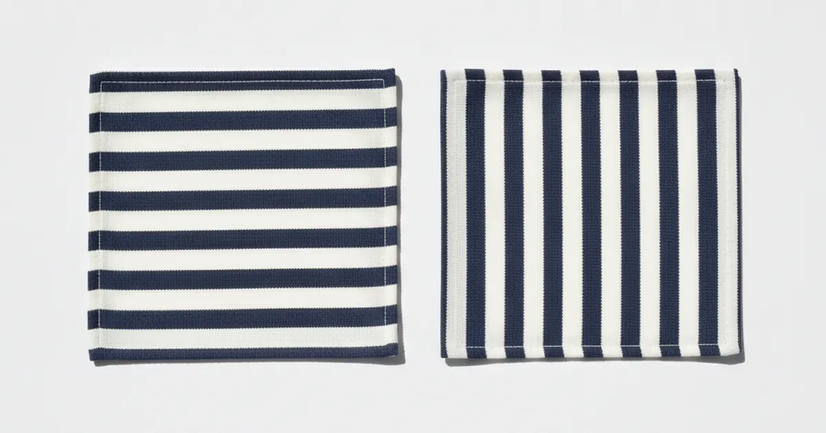 Deux carrés de tissu de taille identique posés côte à côte sur un fond blanc, l'un rayé horizontalement de bleu marine et de blanc, l'autre rayé verticalement des mêmes couleurs