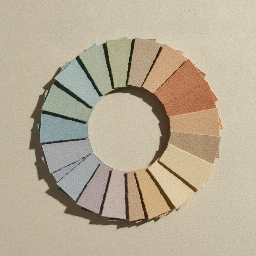 Un cercle de cartons colores dispose en roue continue sur un fond neutre, du froid au chaud puis retour